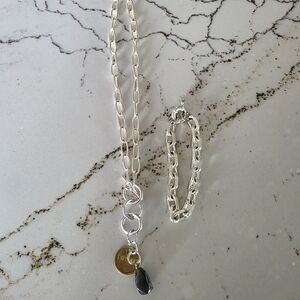 Twisted Silver Necklace And A Silver Toned Bracelet.